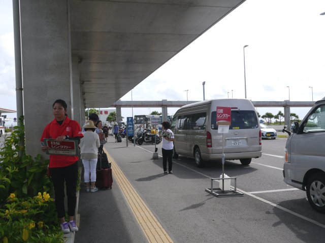 在這個停車場，各間租車公司的職員將手持印有租車公司標誌的牌。